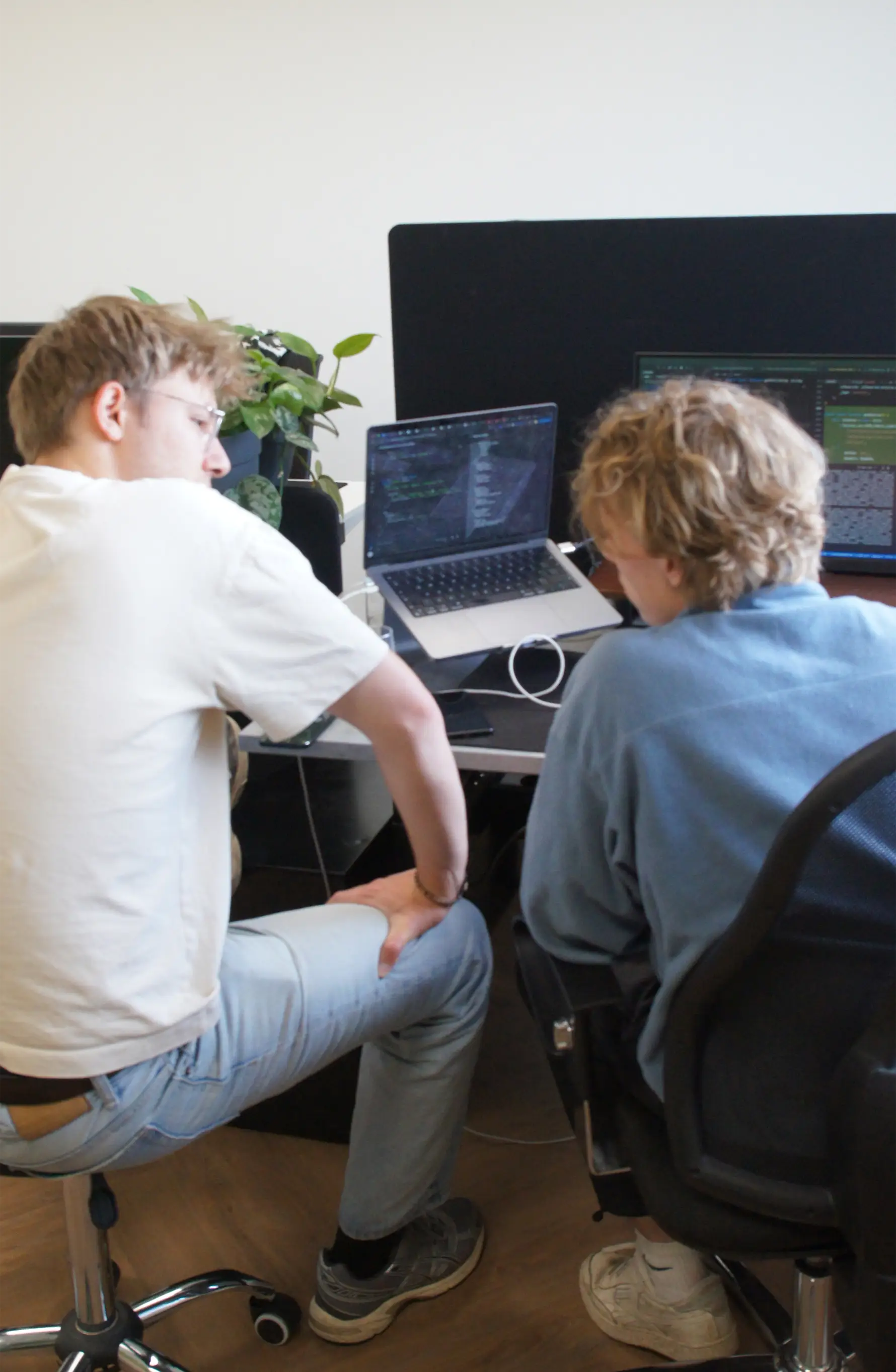 Zwei Teammitglieder von Tinzo arbeiten gemeinsam an einem Laptop